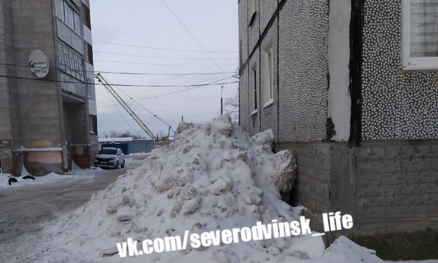 Коммунальщики завалили снегом стены жилых домов по самые окна. Фото vk.com/severodvinsk_life